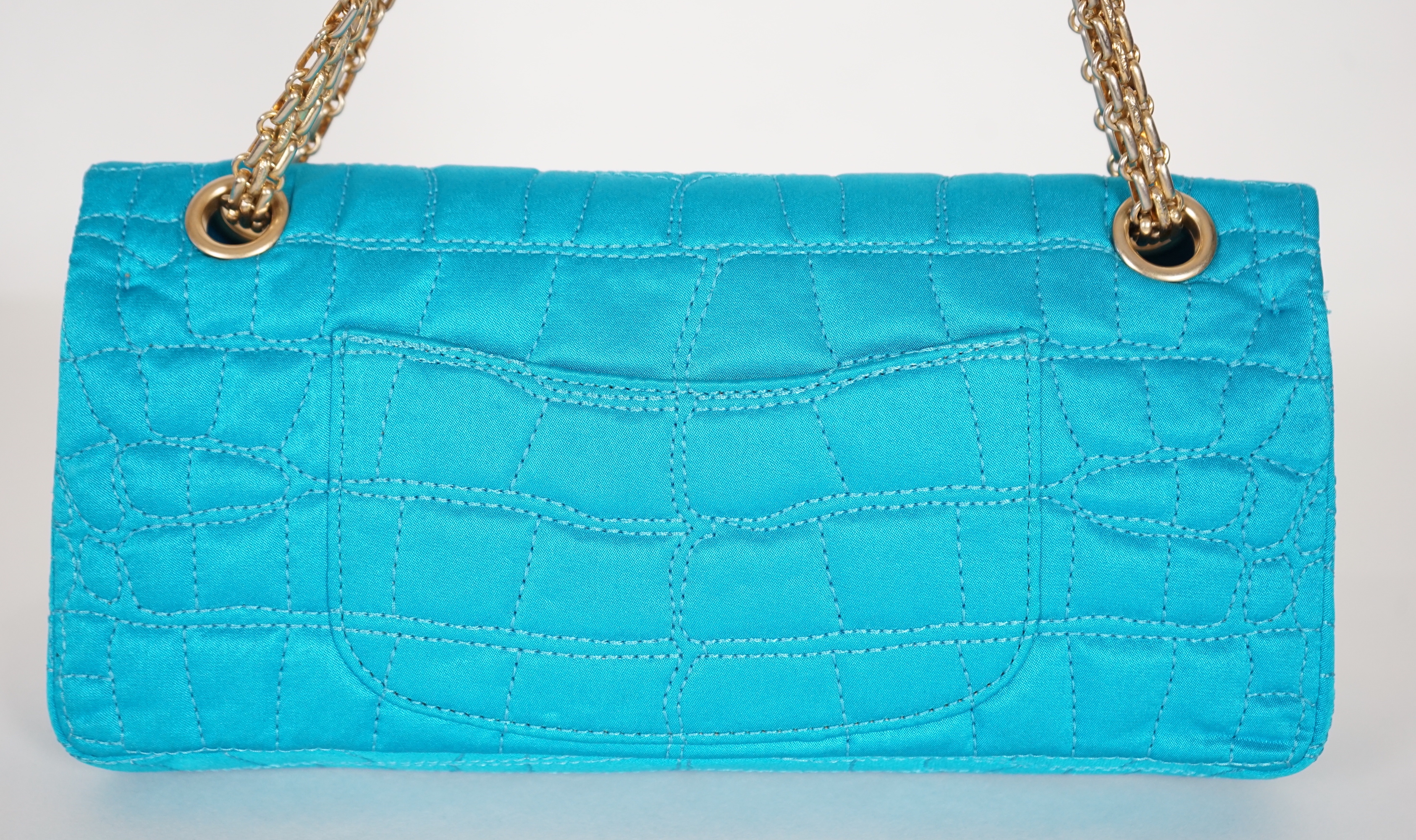 A Chanel medium-sized 2-55 bag in turquoise blue silk satin stitched with a quilted crocodile pattern, width 24cm, height 15cm, depth 6cm, Single handle 112cm, Double handles 65cm